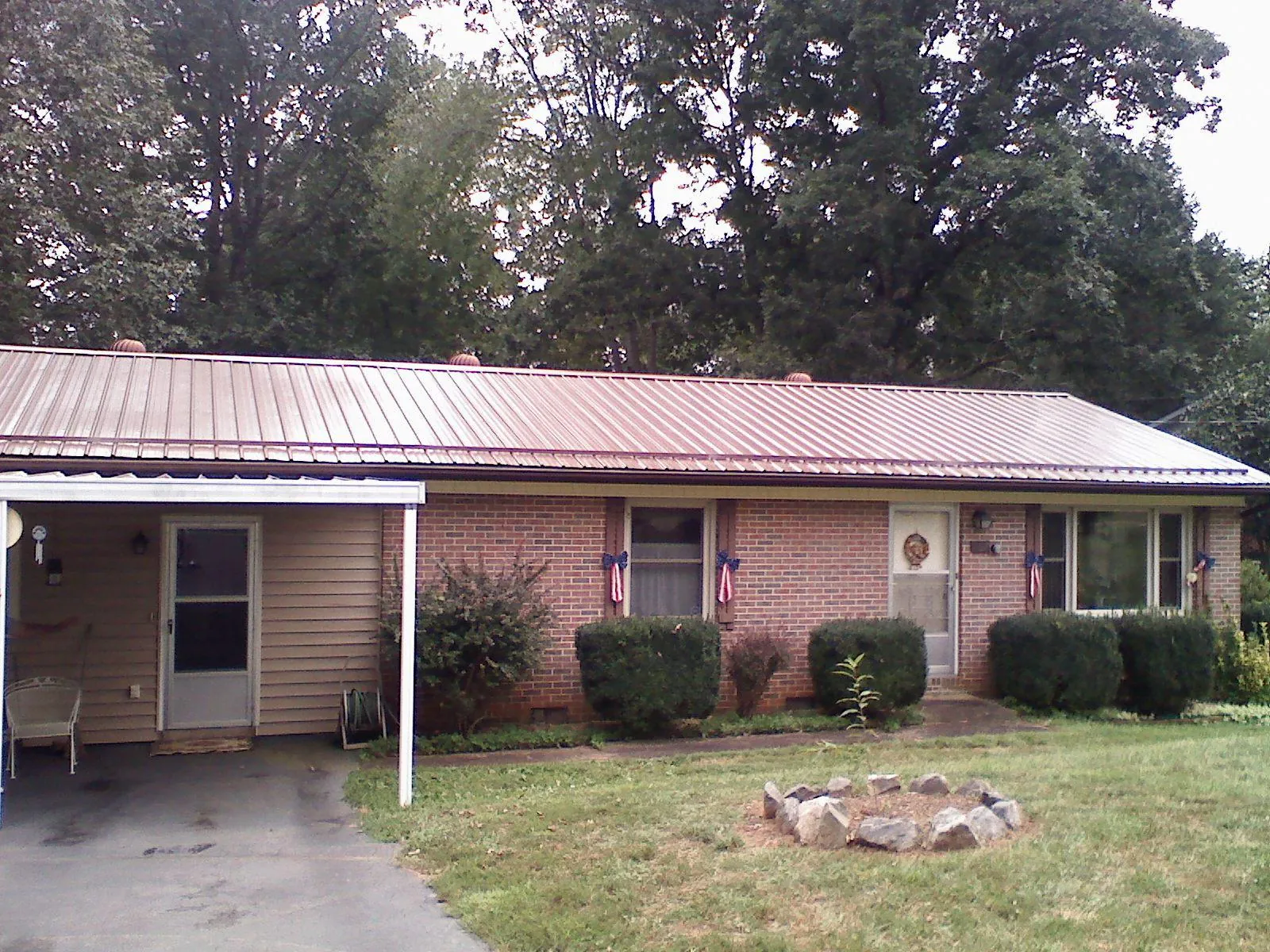 Bronze metal roof and carport on a brick ranch home — Roof Repair work by our crew in Amsterdam